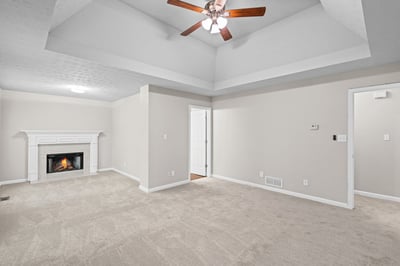 Bright and open living space featuring a cozy fireplace and vaulted ceiling for added character.