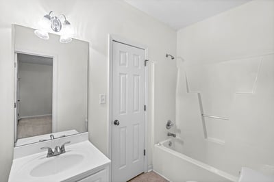 Bright and clean bathroom featuring a spacious bathtub and convenient dual-sink vanity. Ideal for family living.