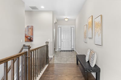 Spacious entryway featuring a welcoming bench, modern artwork, and natural light for a warm ambiance.