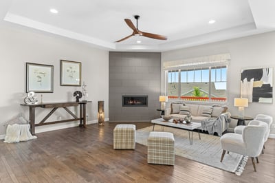 Spacious living area boasts natural light, modern décor, and a cozy fireplace for warm gatherings.