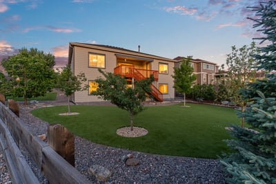 Spacious home with a landscaped yard, featuring mature trees and a welcoming outdoor space for gatherings.