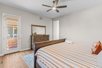 Spacious bedroom featuring natural light, modern ceiling fan, and direct access to an outdoor patio area.