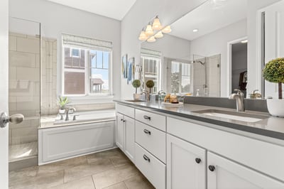 Bright and spacious bathroom featuring dual sinks, abundant natural light, and modern finishes throughout.