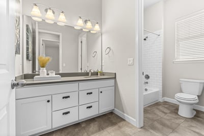 Bright and spacious bathroom featuring modern fixtures, ample storage, and a relaxing tub-shower combination.