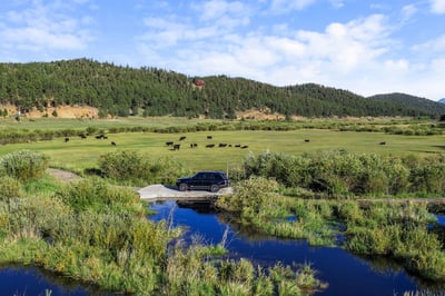 Expansive countryside views with lush greenery, a tranquil waterway, and ample space for outdoor activities.
