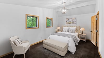 Cozy bedroom featuring a comfortable bed, ample natural light, and distinctive window designs for a unique touch.