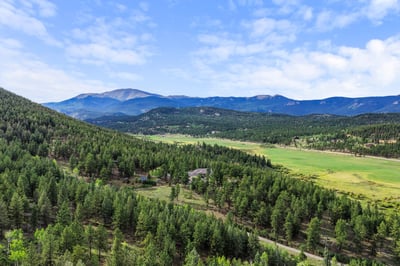 Discover expansive views and natural beauty in this picturesque property surrounded by lush greenery and mountains.