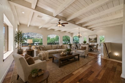 Bright and airy living space features exposed beams, ample natural light, and a seamless flow to dining areas.