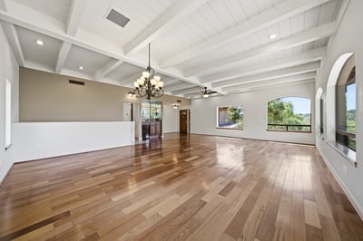 Spacious living area with high ceilings and large windows, showcasing expansive natural light and scenic views.