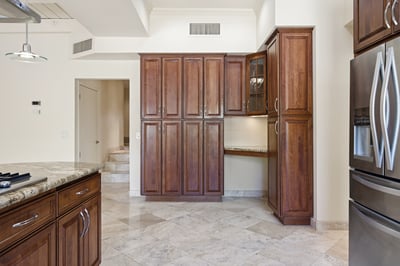 Modern kitchen featuring rich wood cabinetry and ample storage, complemented by granite countertops and stainless appliances.