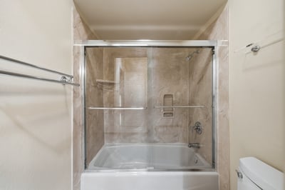 Modern bathroom featuring a sleek glass shower enclosure and spacious soaking tub for ultimate relaxation.