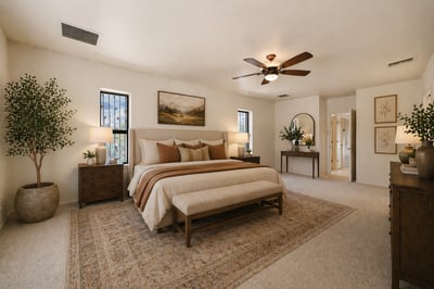 Spacious master bedroom featuring a cozy seating area, large windows, and warm, inviting decor throughout.