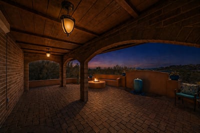Spacious outdoor patio features a cozy fire pit and stunning sunset views, ideal for gatherings.