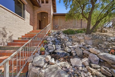 Experience a unique entry with natural stone landscaping and a welcoming water feature, leading to your new home.