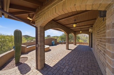 Spacious covered patio featuring unique desert landscaping and stunning mountain views, perfect for outdoor gatherings.