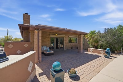 This spacious patio features southwestern architecture, surrounded by lush vegetation and stunning desert views.