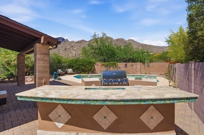 Discover an inviting outdoor entertainment space featuring a built-in grill and stunning mountain views.