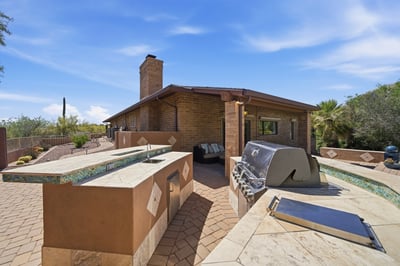 Experience outdoor living with a spacious patio featuring a barbecue area and panoramic desert views.