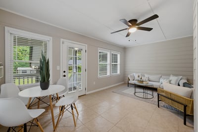 Light-filled sunroom featuring modern furnishings and a cozy seating area, perfect for relaxing or entertaining.