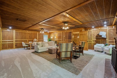 This spacious living area features warm wood accents, plush carpeting, and ample natural light for relaxation.