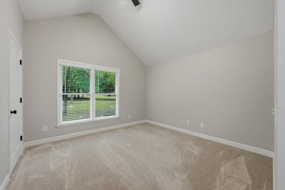 Spacious bedroom with vaulted ceiling.