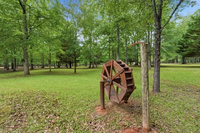 Discover a unique property featuring beautiful natural surroundings and an eye-catching vintage water wheel.
