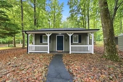 Cottage features a covered front porch, an open living area, kitchenette, private bedroom, and full bath. A versatile space that offers flexibility and functionality, perfect for hosting guests, working from home, or creating a studio or hobby space.