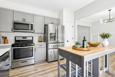 A kitchen island adds an extra countertop space for meal prep, baking, or entertaining. New quartz countertops and subway back splash.