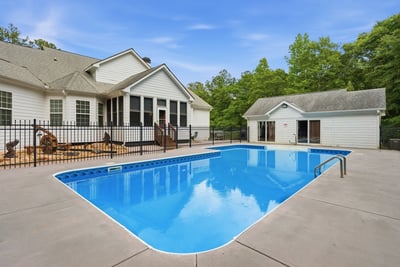 This spacious property features a generously sized pool surrounded by a fenced patio, perfect for outdoor gatherings.