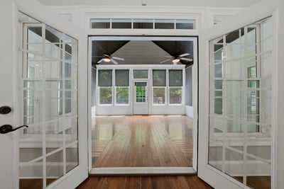 Sunroom featuring large windows and hardwood floors, perfect for entertaining or relaxing.
