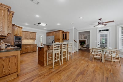 Spacious open-concept kitchen features warm beautiful cabinetry, a large island, and seamless flow to the dining area. Some cabinets have pull out shelves, which makes staying organized easy.