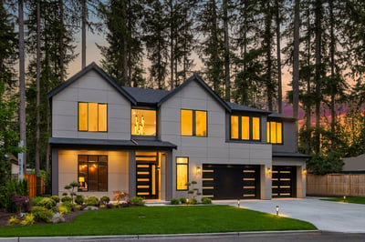 As evening settles in, warm interiors glow through expansive windows, creating a welcoming retreat surrounded by nature.