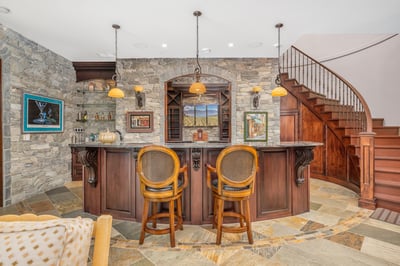 Discover a unique bar area featuring stone accents, custom cabinetry, and inviting seating, perfect for wine tasting.