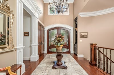 Spacious entryway featuring a stunning chandelier and intricate architectural details, perfect for welcoming guests with "sizzle".