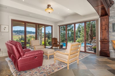 Spacious living area featuring large windows that frame picturesque views, perfect for relaxation and entertaining. Formerly the site of an 8' Spencer Marston Venetian Pool Table, recently re-felted and ready to reassemble if an owner should wish.