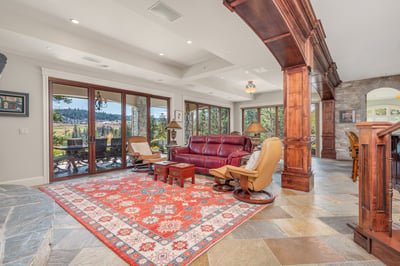 Spacious living area features large windows, natural light, and direct access to scenic outdoor views.