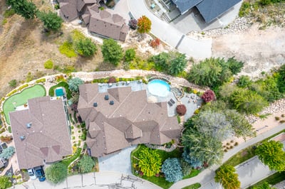 Stunning aerial view showcasing a beautifully landscaped property with a pool nestled in a tranquil neighborhood.