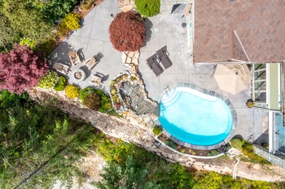 Discover a beautifully landscaped outdoor oasis featuring a pool, waterfall, and cozy seating areas.