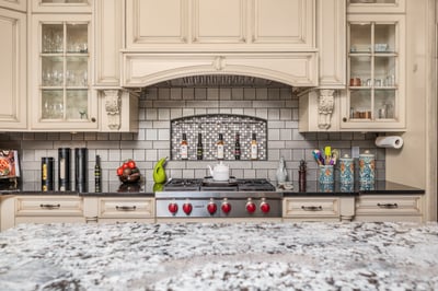 This well-appointed kitchen features modern appliances, custom cabinetry, and a striking mosaic backsplash for captivating culinary experiences.