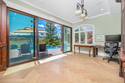 Bright and airy room featuring large windows, beautiful hardwood floors, and stunning poolside views.
