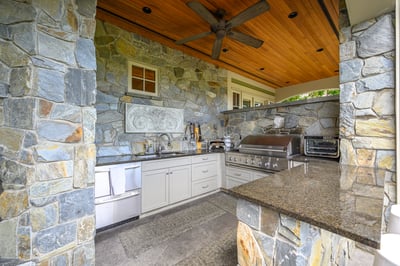 Discover this outdoor kitchen featuring natural stone finishes, premium appliances, and a spacious layout for entertaining.