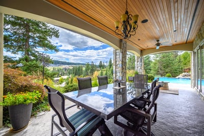 Spacious outdoor dining area with stunning views, perfect for entertaining amidst lush landscaping and a poolside retreat. Large thick granite table.