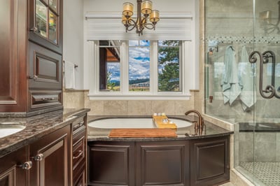 This luxurious bathroom features a soaking tub, modern fixtures, and stunning outdoor views from the window.