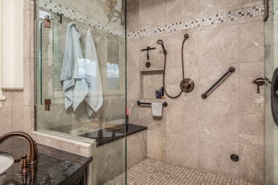 This beautifully designed bathroom features a spacious walk-in steam-shower with modern fixtures and practical accessibility.