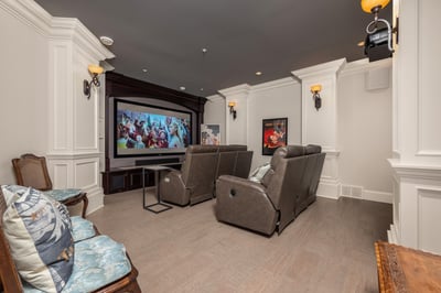 Experience cinematic enjoyment in this dedicated home theater, complete with plush seating and a large projector screen.