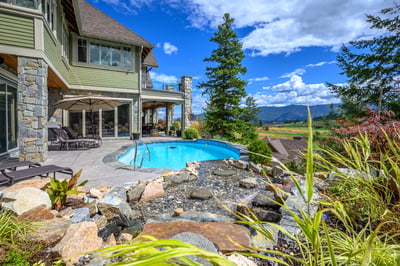 Discover a stunning outdoor oasis featuring a pool, landscaped gardens, and breathtaking mountain views.