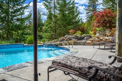 Relax by the inviting pool surrounded by lush landscaping and vibrant greenery, perfect for outdoor enjoyment.