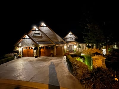 Stunning nighttime view of a beautifully illuminated home featuring a spacious driveway and captivating architecture.