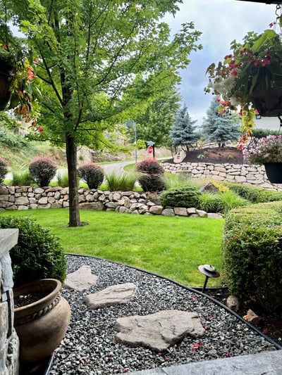 Inviting outdoor space features landscaped gardens, mature trees, and a peaceful view of the surroundings.