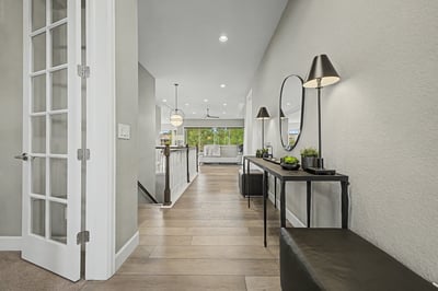 Bright, open hallway leads to a spacious living area, featuring modern fixtures and inviting natural light.
